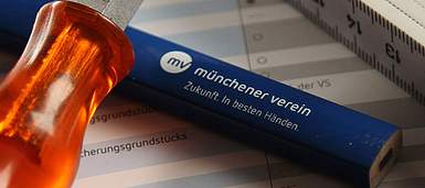 Bleistift, Zollstock und Schraubenzieher liegen auf einem Produktinformationsblatt des Münchener Verein